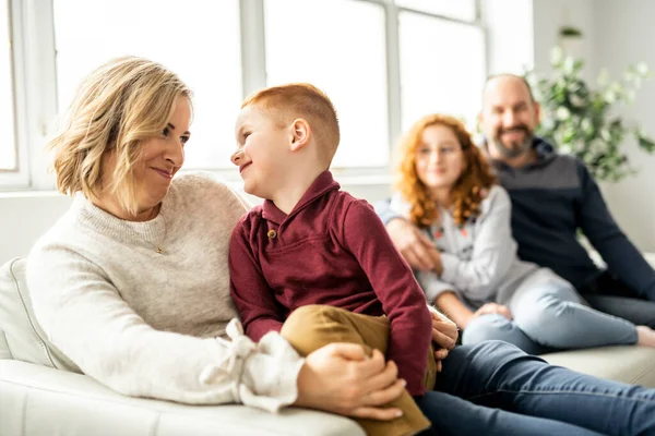 Una hermosa familia feliz divirtiéndose en el sofá en casa — Foto de Stock