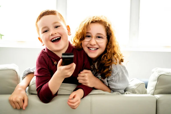 幸せな女の子と男の子見るテレビとともにリモートコントロール — ストック写真