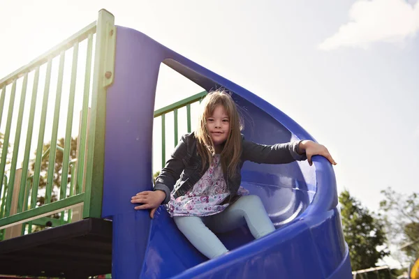 Un portrait de trisomie 21 enfant fille dehors avoir du plaisir sur un parc — Photo