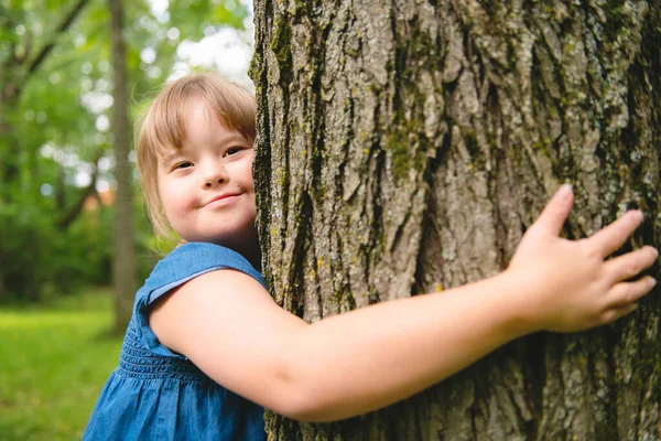 A portrait of trisomie 21 child girl outside having fun on a park — Stock Photo, Image