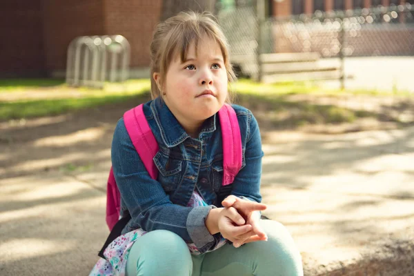 Un ritratto di trisomie 21 bambina fuori su un parco giochi della scuola — Foto Stock