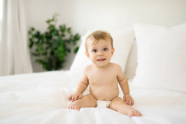 Menina bebê feliz bonito na fralda na cama — Fotografia de Stock