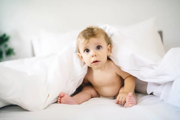 Menina bebê feliz bonito na fralda na cama — Fotografia de Stock
