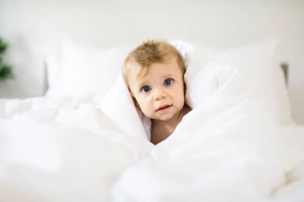 Симпатичная счастливая девочка в пеленке на кровати — стоковое фото