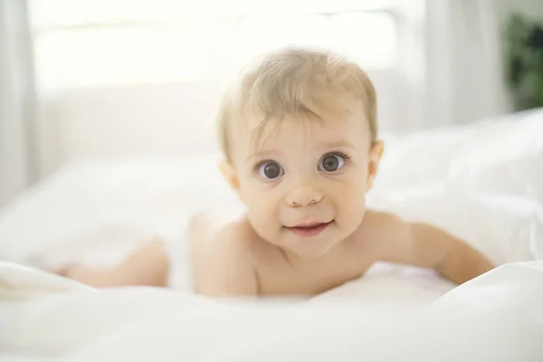 Χαριτωμένο χαρούμενο κοριτσάκι με πάνα στο κρεβάτι — Φωτογραφία Αρχείου