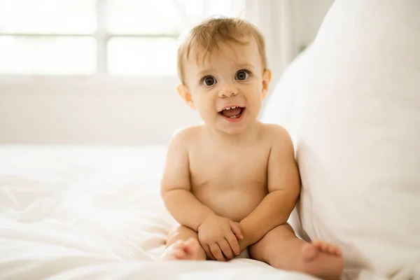 Menina bebê feliz bonito na fralda na cama — Fotografia de Stock