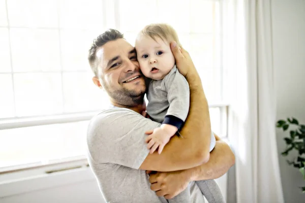 Un padre con un lindo hijo bebé en la cama en casa — Foto de Stock