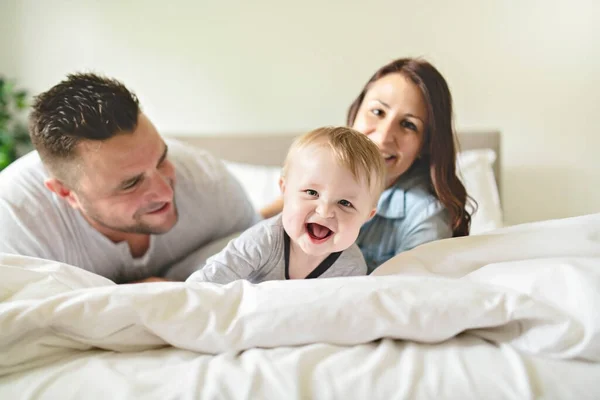 Gelukkig familie moeder, vader en zoon thuis in bed — Stockfoto