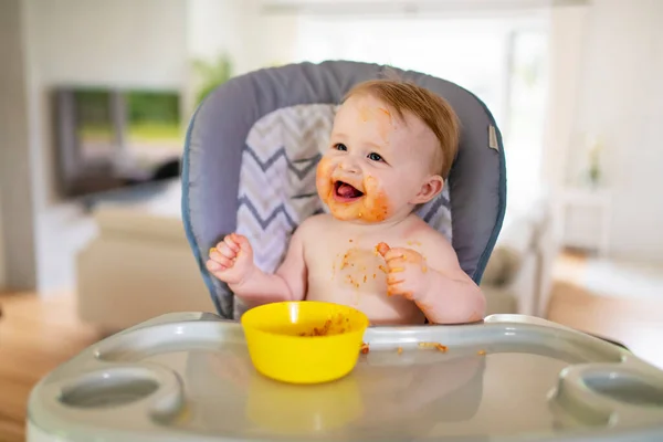 Un pequeño bebé comiendo su cena y haciendo un lío — Foto de Stock