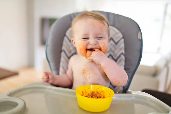 Un pequeño bebé comiendo su cena y haciendo un lío — Foto de Stock