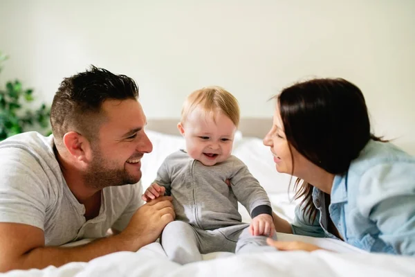 Feliz familia madre, padre e hijo en casa en la cama — Foto de Stock