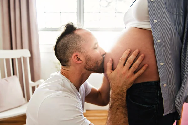 Ehemann auf dem Babyzimmer zu Hause mit Schwangerschaftsbauch — Stockfoto