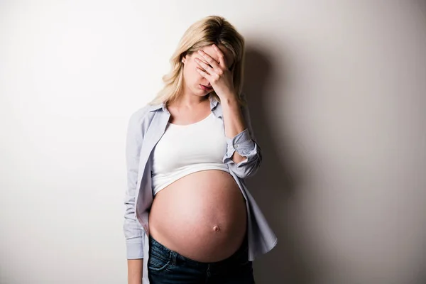 Donna incinta con un sacco di stress su sfondo bianco — Foto Stock