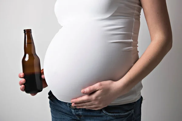 Mulheres grávidas bebendo cerveja no estúdio branco — Fotografia de Stock