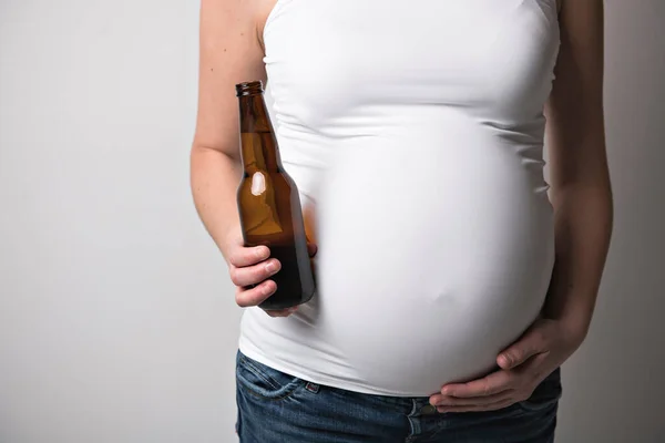 Mulheres grávidas bebendo cerveja no estúdio branco — Fotografia de Stock