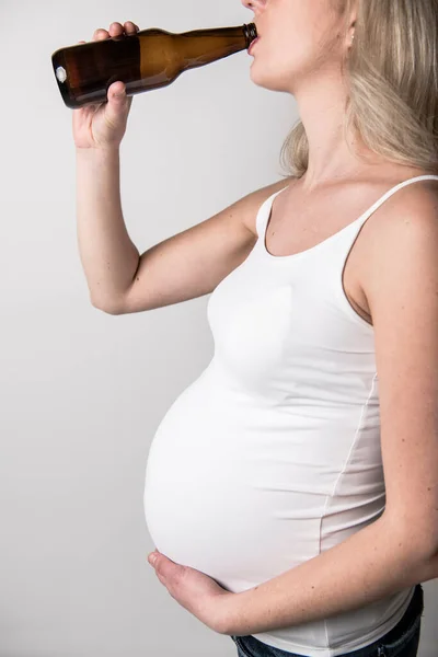 妊娠中の女性飲むビール上のスタジオホワイト — ストック写真