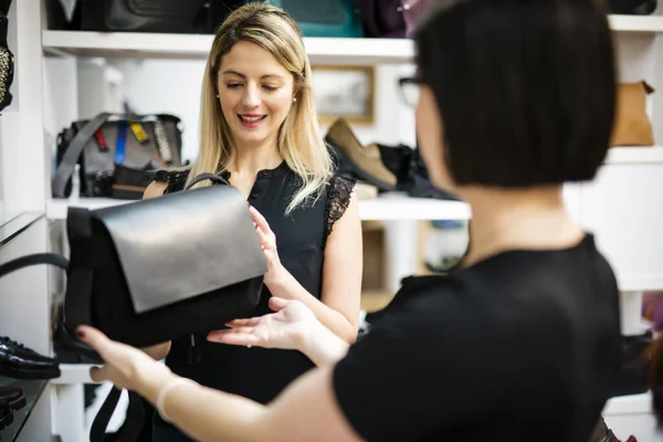 Young female shopper choosing the handbag matching her casual style — Stock Photo, Image