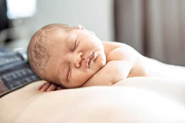 Um bebê recém-nascido deitado dormindo sobre o pai de volta — Fotografia de Stock