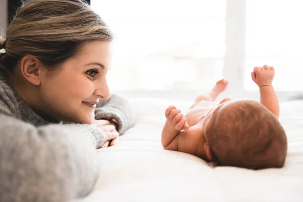 Madre se acostó en la cama con su hija recién nacida — Foto de Stock