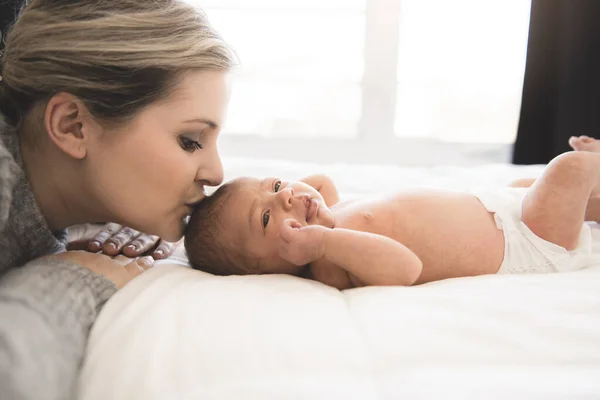 Mother lay on bed with his newborn baby daughter — Stock Photo, Image