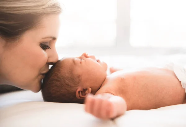 Mother lay on bed with his newborn baby daughter — Stock Photo, Image