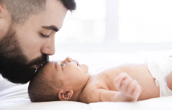 Отец лежал на кровати со своей новорожденной дочкой — стоковое фото