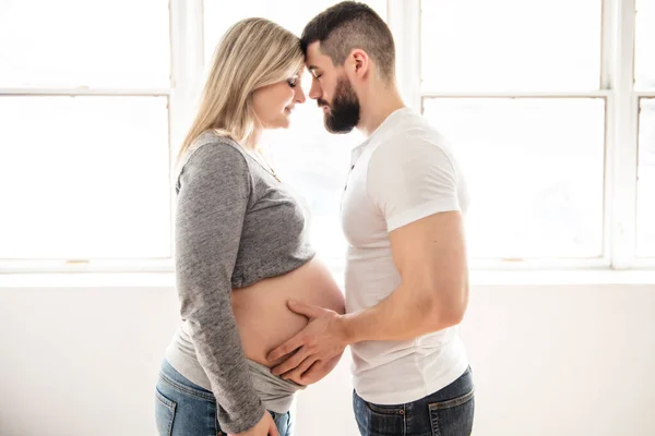 Mujeres embarazadas con su marido sintiéndose felices en casa —  Fotos de Stock