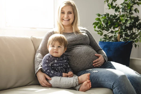 En lycklig gravid mor och liten son hemma — Stockfoto