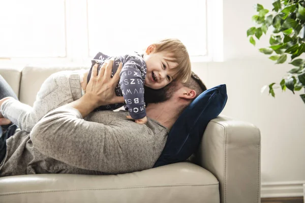 Um pai e um filho brincando na sala de estar juntos — Fotografia de Stock