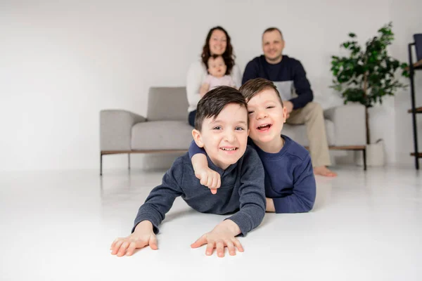 Молода сім'я вдома з дитиною сидить на дивані — стокове фото