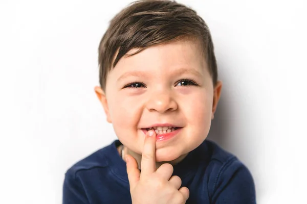 Close portret van een vier jaar oude jongen over witte wijzende tand — Stockfoto