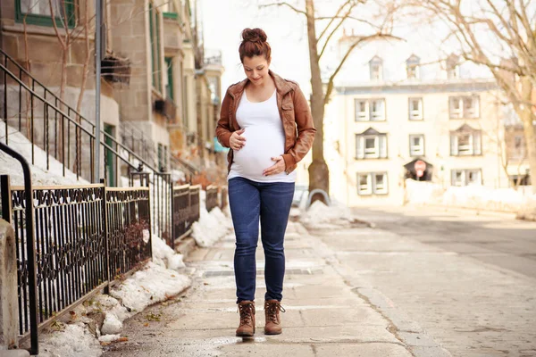Беременная девушка на улице на городском фоне — стоковое фото