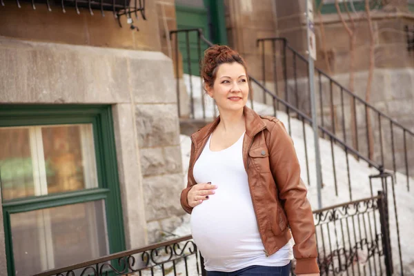 Chica embarazada fuera en un fondo de la ciudad —  Fotos de Stock