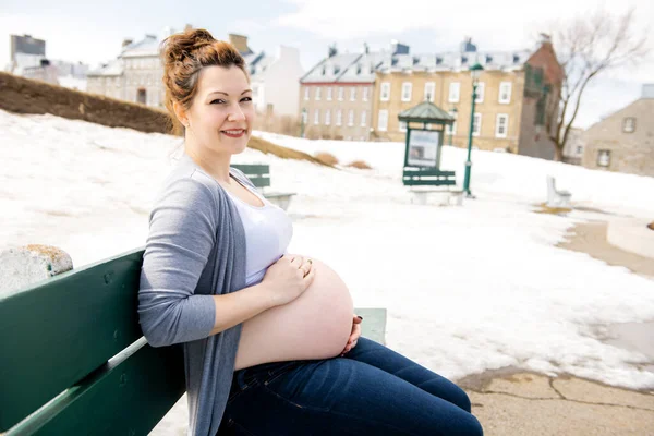 Schwangere Mädchen draußen vor dem Hintergrund der Stadt — Stockfoto