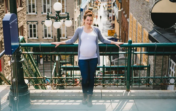 도시의 배경에 나타나 있는 임신 한 여자 — 스톡 사진