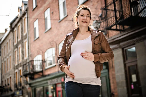 Schwangere Mädchen draußen vor dem Hintergrund der Stadt — Stockfoto