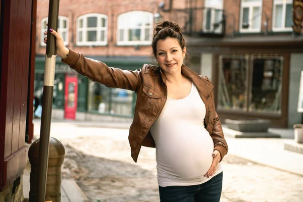 Schwangere Mädchen draußen vor dem Hintergrund der Stadt — Stockfoto