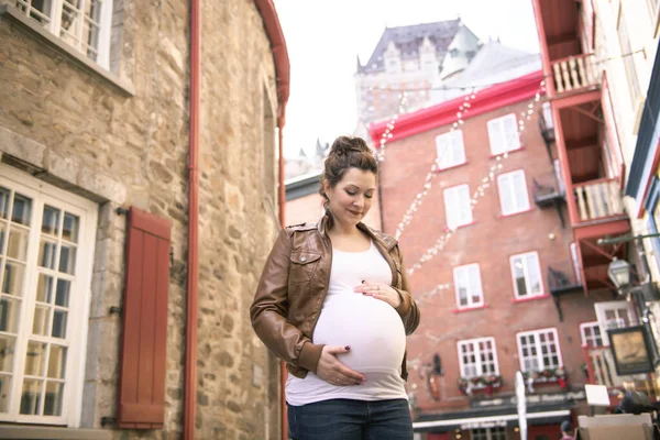 Беременная девушка на улице на городском фоне — стоковое фото