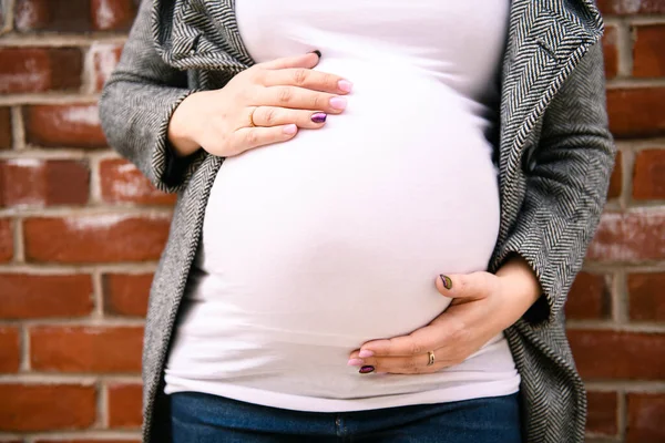 Chica embarazada fuera en un fondo de la ciudad — Foto de Stock