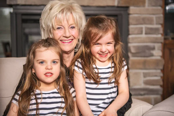 Portrait de grand-mère avec leur petit enfant jumeau assis sur le canapé à la maison — Photo