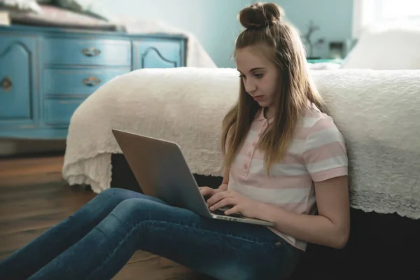 Молодая улыбающаяся девушка-подросток в постели с ноутбуком — стоковое фото