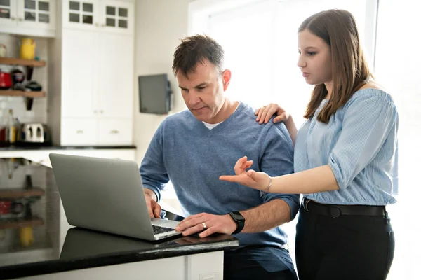 Egy apa laptopot használ a konyhában tinédzserekkel. — Stock Fotó