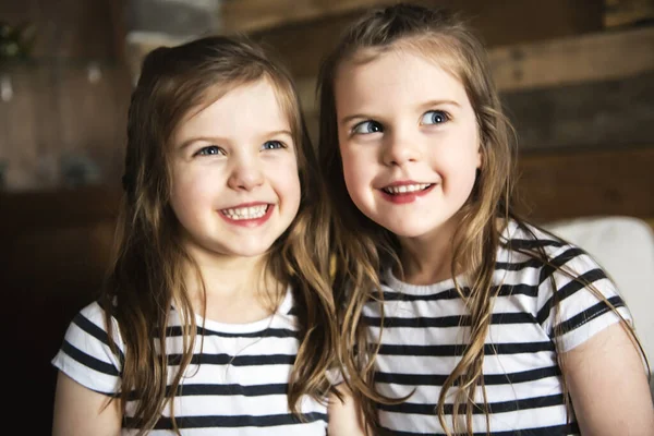 Šťastná dvojčata objímající se v obýváku — Stock fotografie