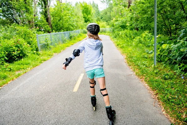 Дитина на ковзанах. Маленька дівчинка катається на сонячному літньому дні . — стокове фото