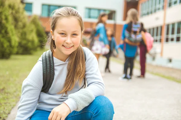 Eine Schülerin am ersten Schultag auf dem Schulhof — Stockfoto