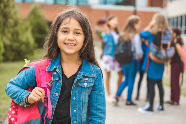 A student school girl on the playground on the first day of class