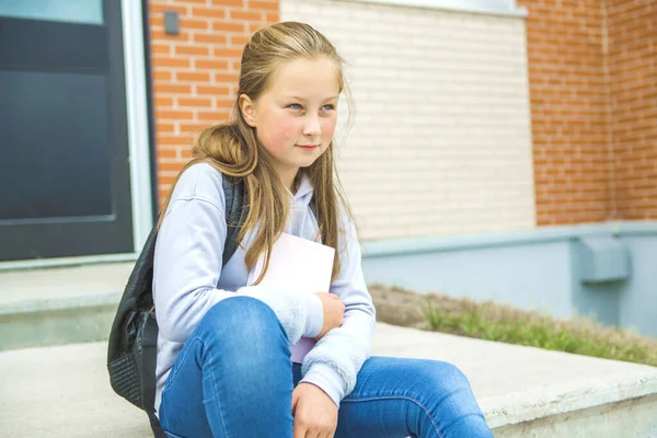 A student school girl on the playground on the first day of class