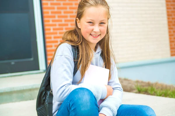 Eine Schülerin am ersten Schultag auf dem Schulhof — Stockfoto