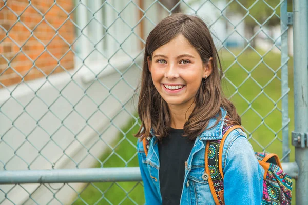 A student school girl on the playground on the first day of class