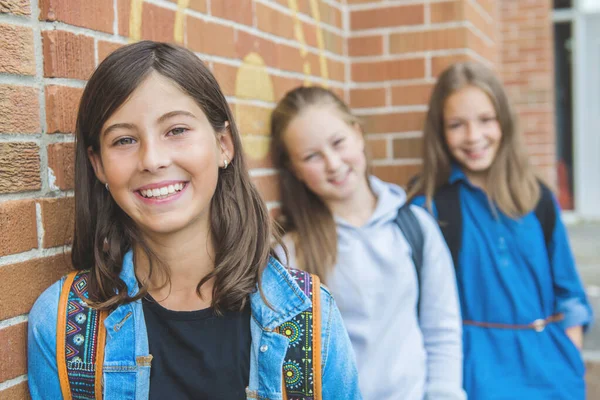 Alcuni ragazzi simpatici sullo sfondo della scuola si divertono — Foto Stock